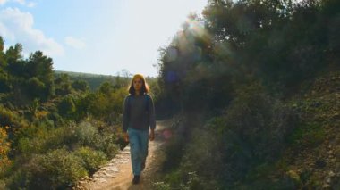 Bir çocuk sırt çantasıyla bir patika boyunca yürüyor. Gezinti ve yürüyüş. Dağlarda sırt çantalı bir çocuk. İsrail 'de seyahat