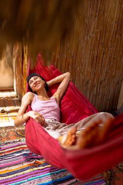 Hamakta yatan kız. Yaz tatilinin tadını çıkaran mutlu genç bir kadın. Romantik tasasız ruh hali konsepti. Yaz havası.