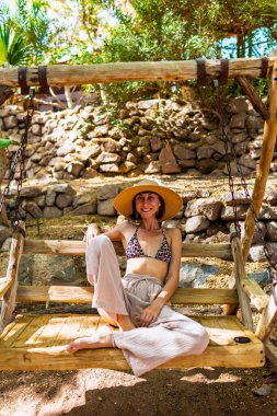 Plajın yakınındaki bir kafede sallanan bir kız, plajda güneşli sıcak bir gün. Tatildeki kız.