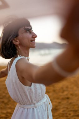 Özgürlük mutlu genç kız deniz kenarında yürüyor. Seyahat, tatil, yaz gezileri. Sahildeki kız..