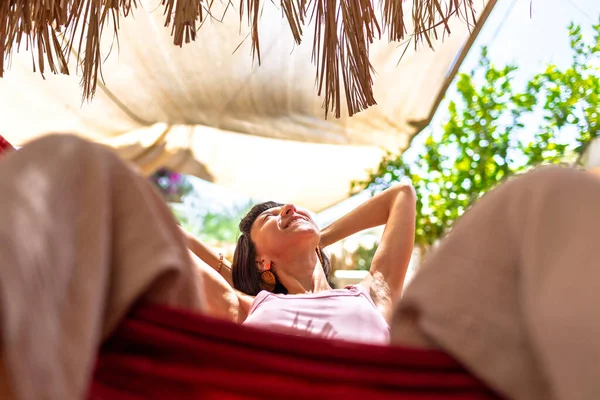 Hamakta yatan kız. Yaz tatilinin tadını çıkaran mutlu genç bir kadın. Romantik tasasız ruh hali konsepti. Yaz havası.