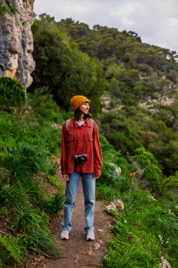Sırt çantalı bir kızın portresi. Dağlarda yürüyüş yapan ve yolculuğun tadını çıkaran bir kadın. Aktif eğlence ve spor.