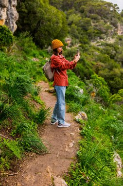 Bir kız sosyal medya için video çekiyor. Sırt çantalı genç bir kadın. Bir günlük için içerik oluşturuluyor.