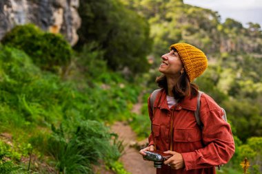 Sırt çantalı bir kız. Dağlarda yürüyüş yapan ve yolculuğun tadını çıkaran bir kadın. Sosyal medya için içerik çeken bir kadın fotoğrafçı. Aktif eğlence ve spor.