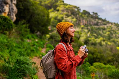 Kameralı bir kız. Seyahat eden ve zamanın tadını çıkaran bir kadın. Sosyal medya için içerik çeken bir kadın fotoğrafçı. Aktif eğlence ve spor.