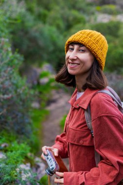 Bir kız fotoğraf çekiyor. Yürüyüş sırasında bir kadın fotoğraf çekiyor. Bir kadın fotoğrafçı sosyal medya için içerik çekiyor. Aktif eğlence ve spor.