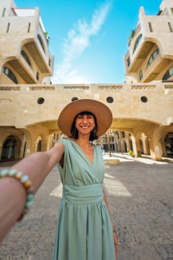 Güzel elbiseli ve şapkalı bir kız seyahat ediyor. Sosyal medyada paylaşmak için selfie çeken sevimli ve güzel, modaya uygun bir kız. Kentte selfie.