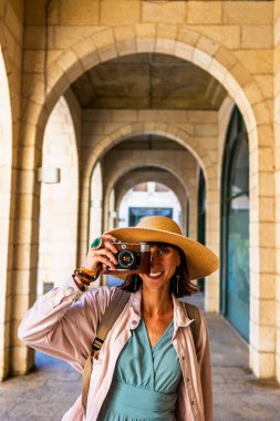 Şehirde fotoğraf çeken bir kadın fotoğrafçı. Genç bayan fotoğrafçı objektife nişan alıyor ve çekim sürecinin tadını çıkarıyor. seyahat ve içerik yaratmak. seyahat ve tatil.
