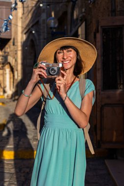 Şehirde fotoğraf çeken bir kadın fotoğrafçı. Genç bayan fotoğrafçı objektife nişan alıyor ve çekim sürecinin tadını çıkarıyor. seyahat ve içerik yaratmak. seyahat ve tatil.