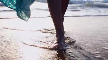 Sahilde bir kız. Uzun elbiseli bir kadın gün batımında sahile doğru yürüyor. Aşk ve aşk. Özgürlük ve...