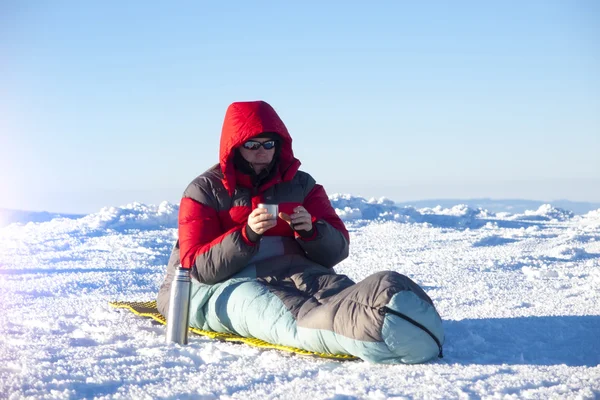 A man sits in a sleeping bag. — Stock Photo, Image