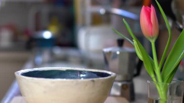 Sıcak bir mutfakta kahvaltı hazırlıyorum. Pişmemiş kuru yulaf ezmesi kaşıktan tabağa dökülüyor. Yakın çekim videosu.