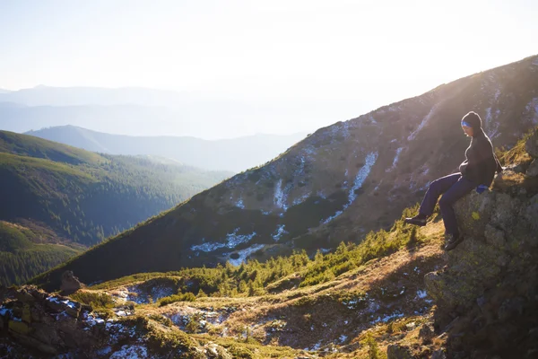 Silhouette einer Frau auf einem Berg sitzend. — Stockfoto