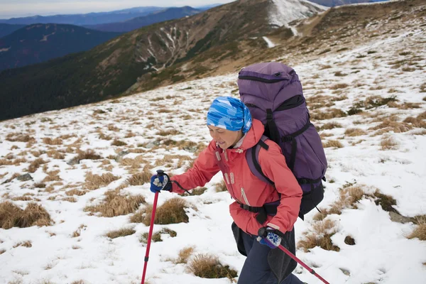 Menina com mochila está viajando nas montanhas . — Fotografia de Stock