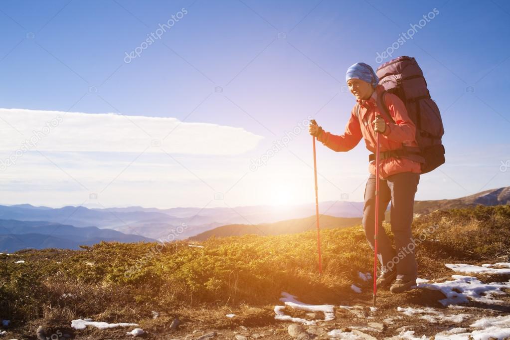 Girl with backpack is traveling in the mountains.