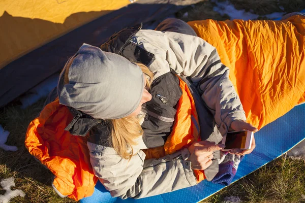 Bir uyku tulumu içinde yalan telefon ile kız.