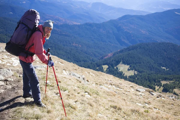 Turista com mochila em pé em uma montanha . — Fotografia de Stock