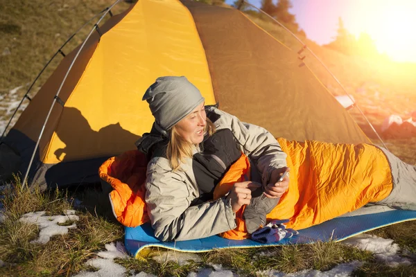 Das Mädchen mit dem Telefon im Schlafsack. — Stockfoto