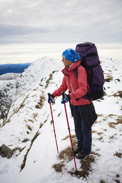 La chica con la mochila va en un sendero de montaña . — Foto de Stock