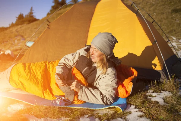 Das Mädchen mit dem Telefon im Schlafsack. — Stockfoto