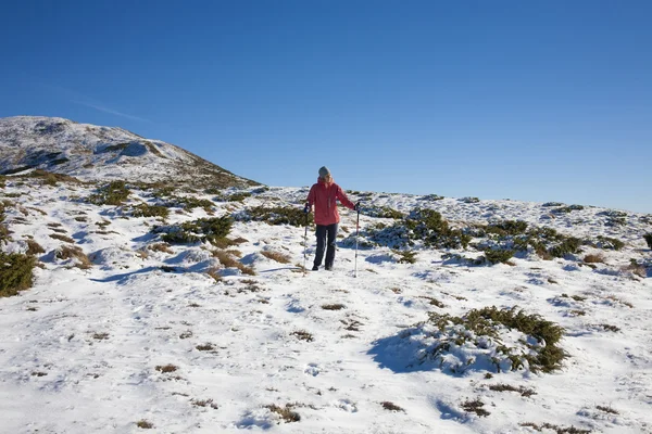 少女が山で雪の中を歩く. — ストック写真