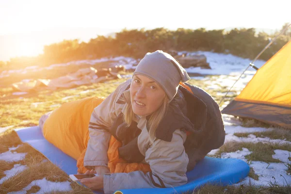 Flickan med telefonen liggande i en sovsäck. — Stockfoto