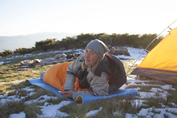 The girl with the phone lying in a sleeping bag. — Stock Photo, Image