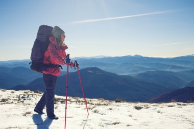 Çantalı kız kar üzerinden gider.