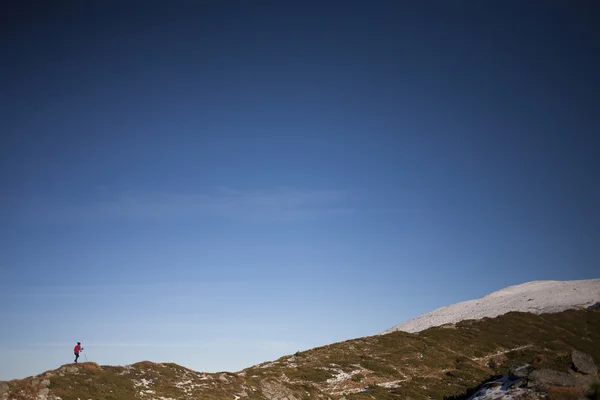 Mulher silhueta que corre ao longo do cume da montanha . — Fotografia de Stock