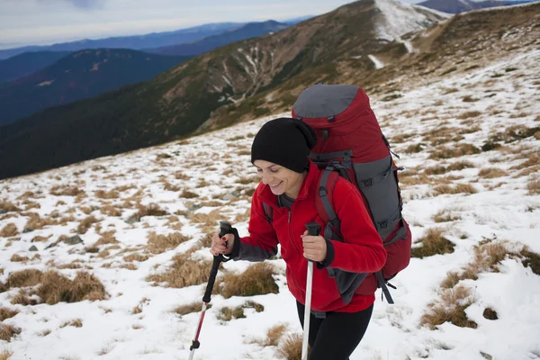 Menina com mochila está viajando nas montanhas . — Fotografia de Stock