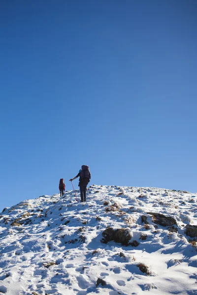 Os montanhistas escalam a encosta nevada . — Fotografia de Stock