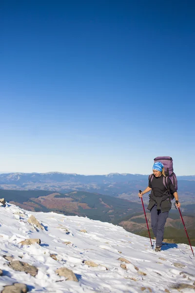 Escalador con una mochila está en una pendiente . — Foto de Stock