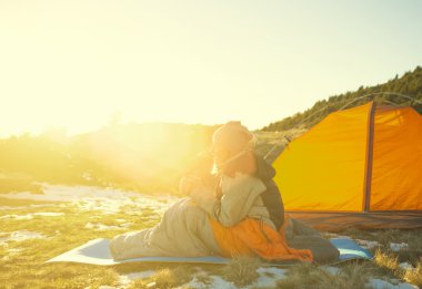 Bir uyku tulumu içinde oturan kız.
