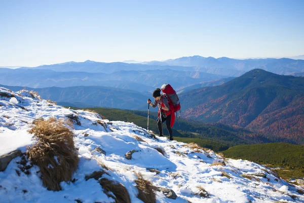 Menina com mochila está viajando nas montanhas . — Fotografia de Stock
