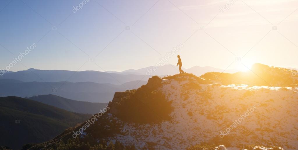 Silhouette of a climber on a mountain ridge.