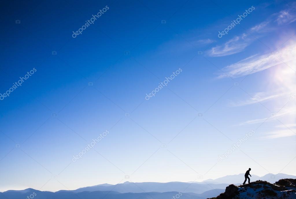 Silhouette of a climber on a mountain ridge.