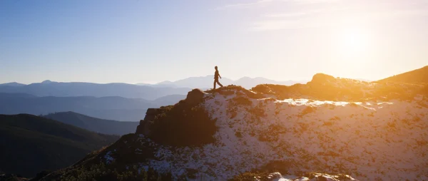 Silhueta de um alpinista em um cume de montanha . — Fotografia de Stock