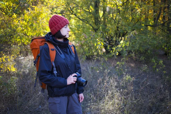 A girl with a camera and a backpack — Stock Photo, Image