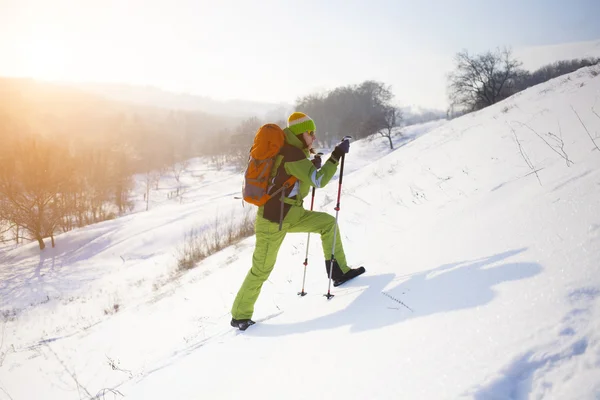 La ragazza con lo zaino sale sulla neve . — Foto Stock