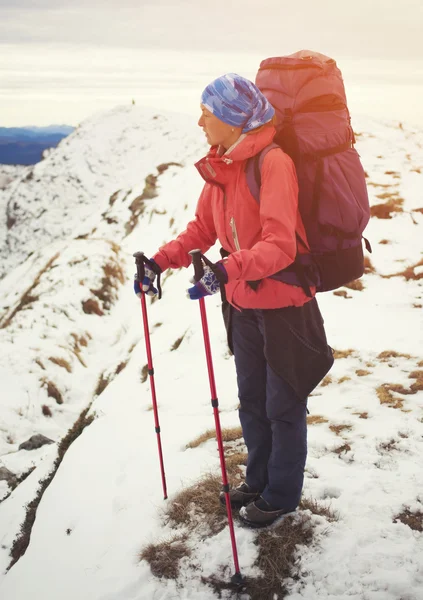 Menina com mochila está viajando nas montanhas . — Fotografia de Stock