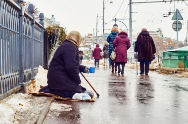 Female beggar asks for money on the Moscow street clipart