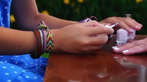 Школьница делает маникюр для своей бабушки — стоковое видео