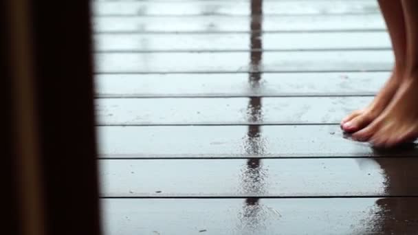 Крупный план босых ног девушки, танцующей на мокром полу под теплым летним дождем — стоковое видео
