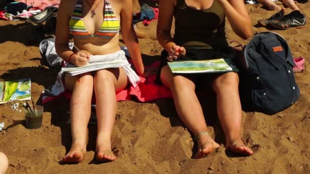 ビーチに座っている水彩画の絵画のビキニを着ている若い女の子 — ストック動画