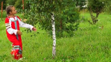 Huş ağacı yakınındaki Rus Halk elbiseli kız