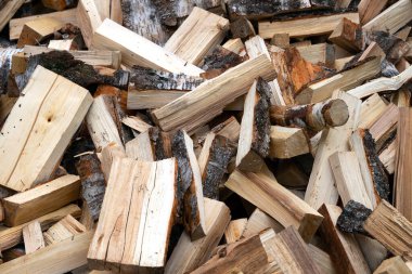 Arkaplanda büyük bir odun yığını var.