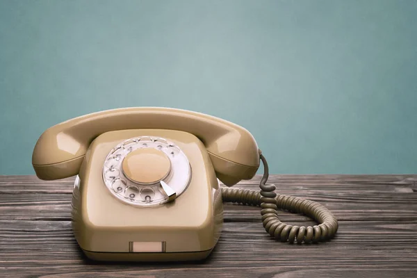 Old telephone set of the 70s of the 20th century stands on the wooden boards isolated on a blue background