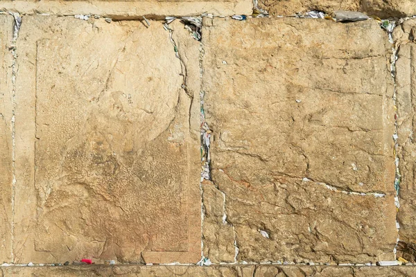 Fragment of the Wailing Wall with paper nortes with requests to god inserted into gaps between stone plates