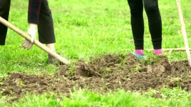 Kadınlar bahçede çalışır. Kızlar kazar ve çapalar bahçe yatağını