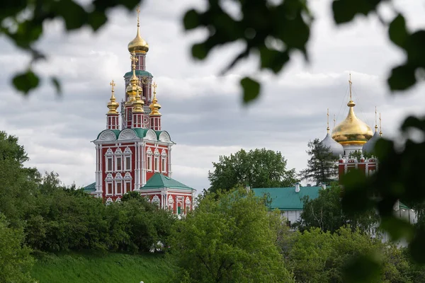 View of the Moscow Novodevichy monastery in spring evening with blurred tree leaves on the foreground — Stock Photo, Image